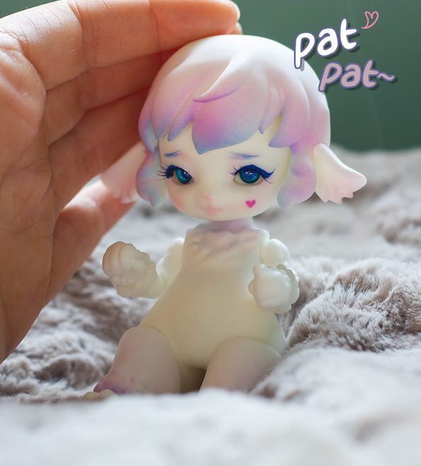 Sheep BJD. It has a pink heart in the cheek.