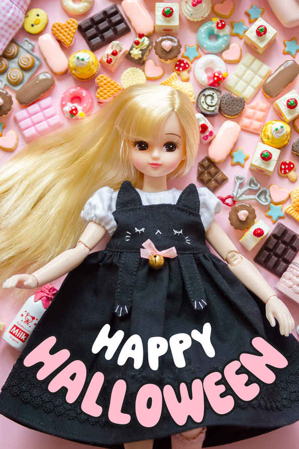 Licca chan resting on a pink background full of sweet treats.